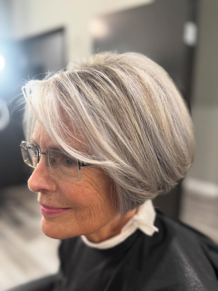 Short silver bob with feathered bangs and soft volume around the face.