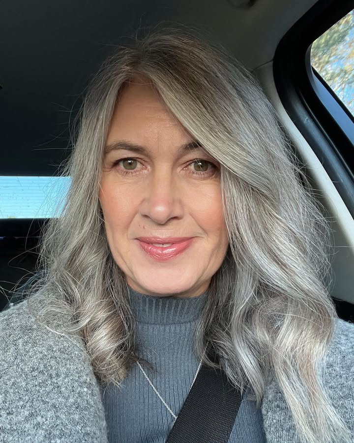 Medium length silver wavy hair with soft side swept bangs and natural shine.
