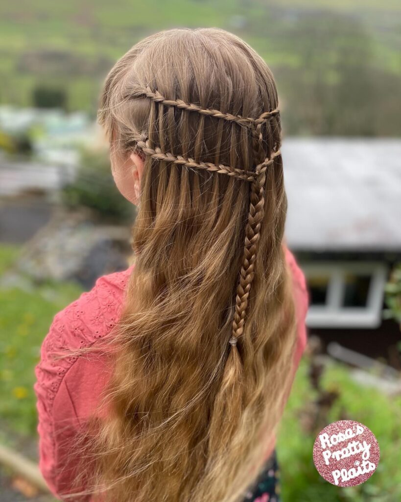 A back view of a girl with long, light brown hair styled in two horizontal waterfall braids that merge into a central vertical braid.