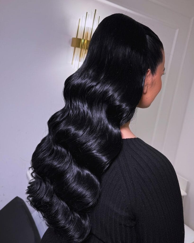 Very long black hair with deep glossy waves and a sleek finish.
