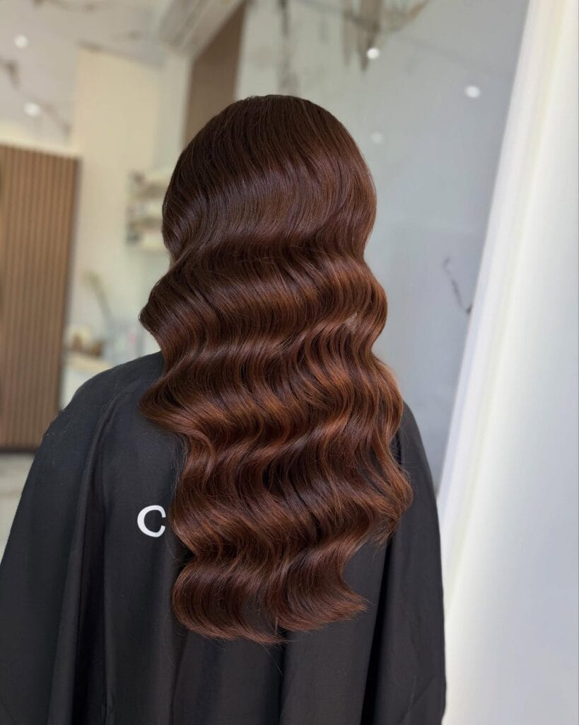 Long dark brown hair with deep sculpted waves and a glossy finish.