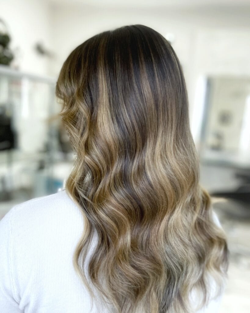 Long wavy hair with balayage highlights and soft blended layers.