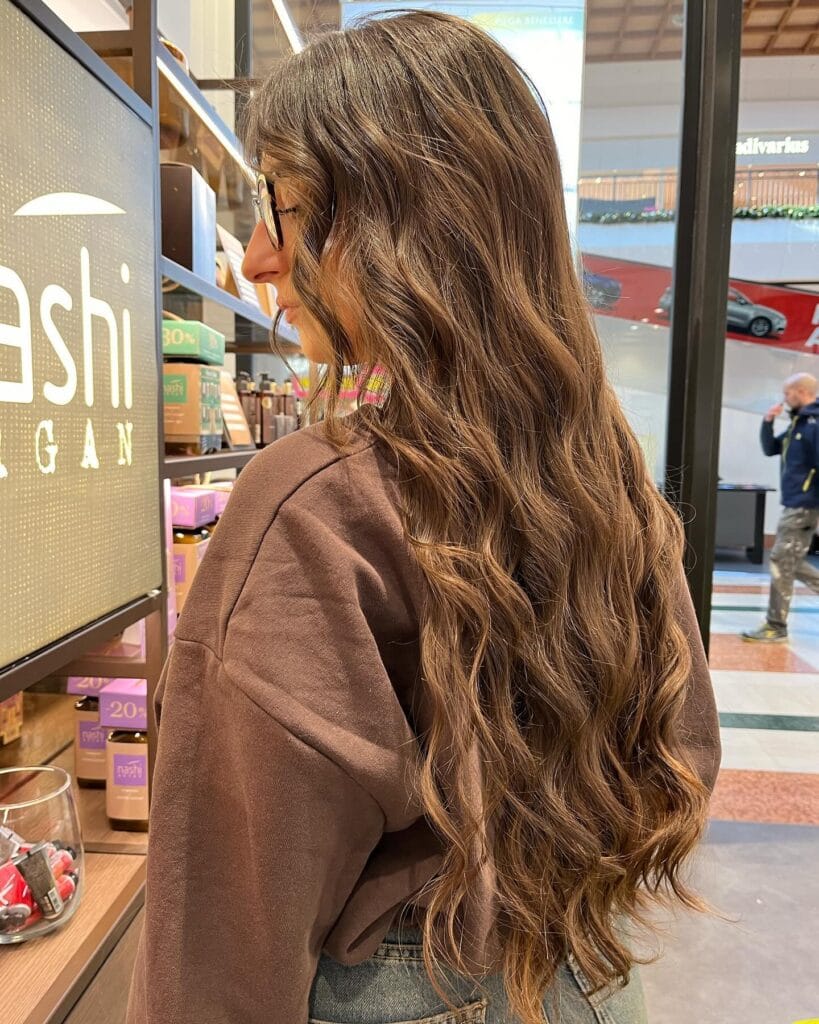 Long brown hair with loose natural waves and soft flowing texture.