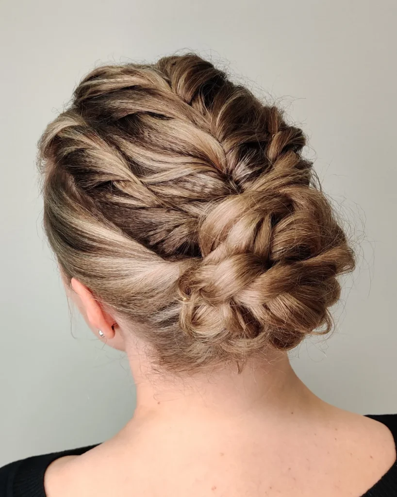 Brunette braided crown hairstyle flowing into a textured low bun.