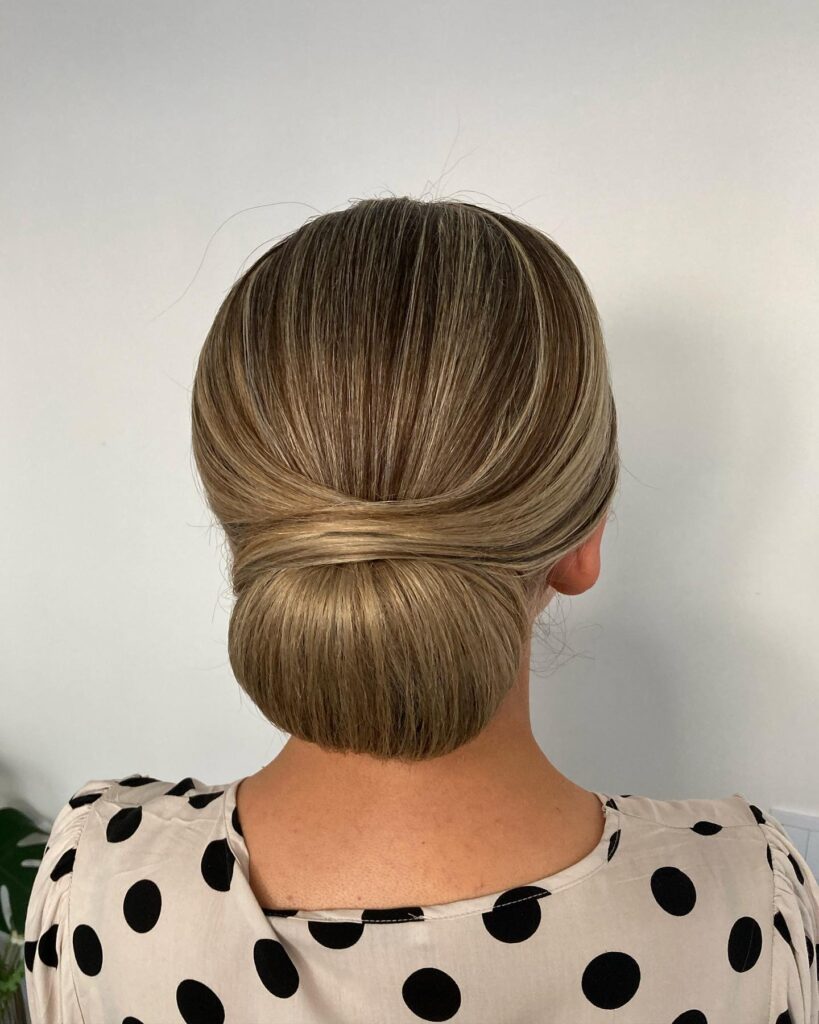 Smooth low bun with neatly combed hair and a classic polished shape