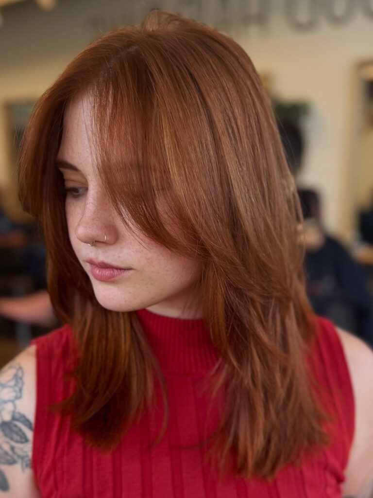 Shoulder length copper hair with soft layers and light face framing pieces.