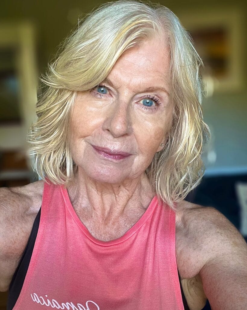 A woman with a neck-length platinum blonde bob featuring soft layers and a side part.