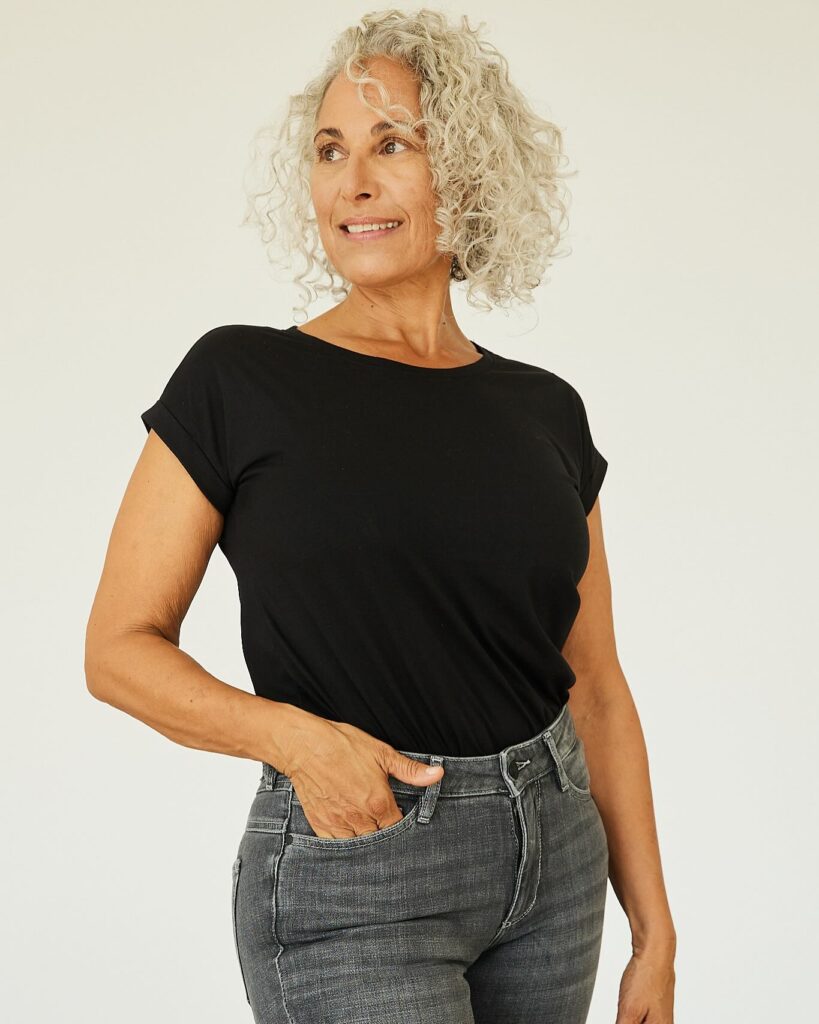 A woman with chin-length silver curls styled with light layers and natural volume.