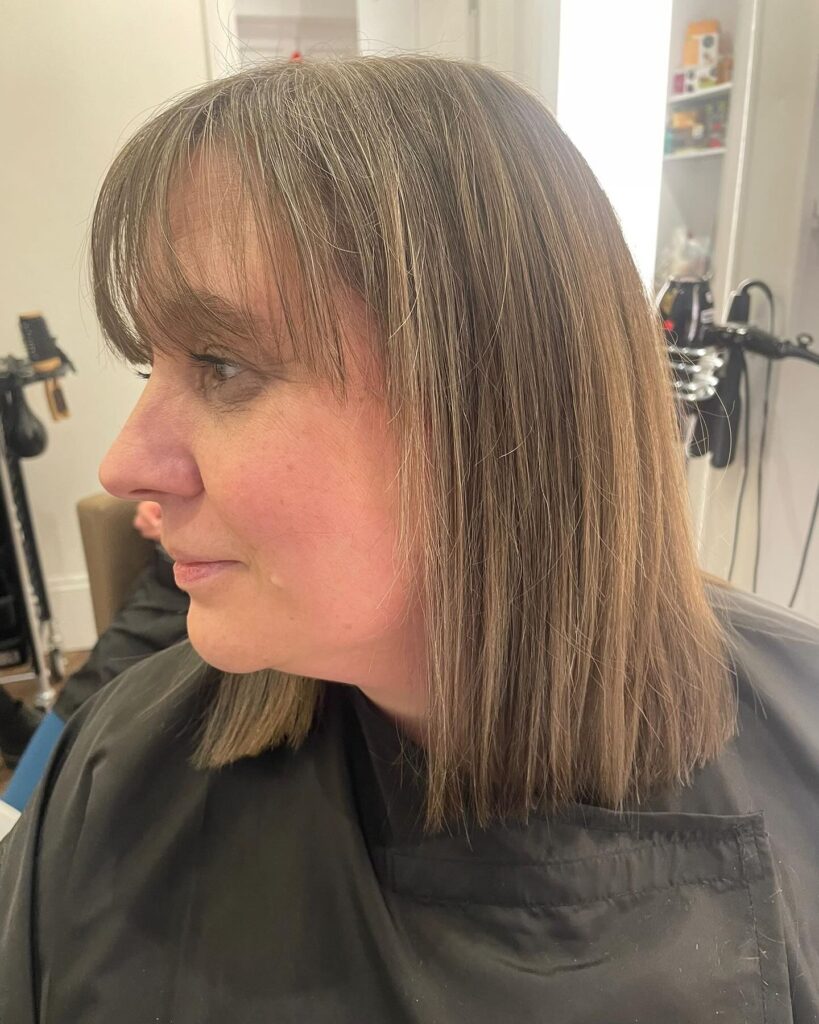 Straight brown bob with full bangs and a smooth natural finish.