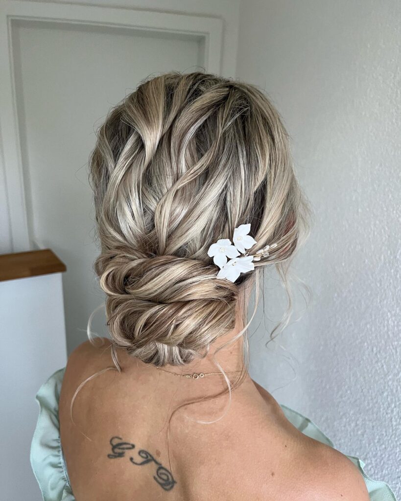 A woman with high-ponytail and a loose, thick side-braid.