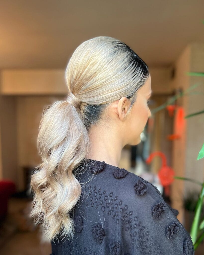 Light blonde low ponytail with soft waves and added volume.