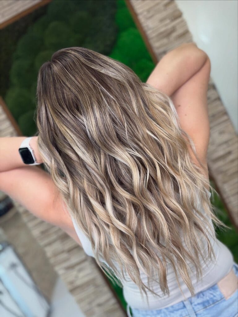 Very long cool blonde wavy hair with soft natural texture and subtle highlights.