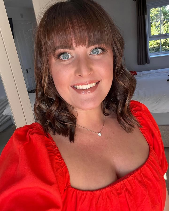 Shoulder length brunette curly hair with full straight bangs and soft volume.