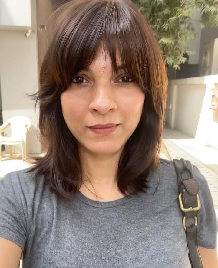 Shoulder length layered dark brown hair with rounded bangs and soft inward shape.