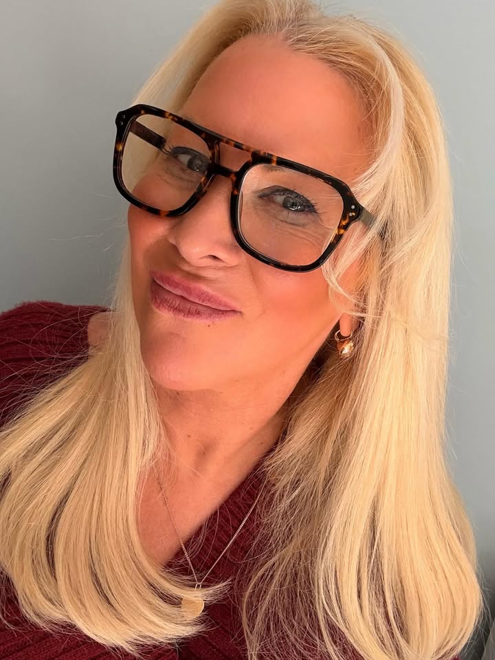 Long straight blonde hair with soft blended fringe worn with glasses.