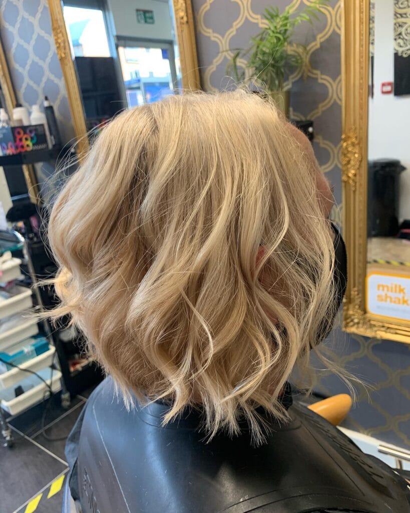 Blonde wavy bob with voluminous layers and soft texture.