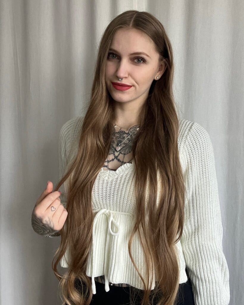 Very long light brown hair with soft waves at the ends.