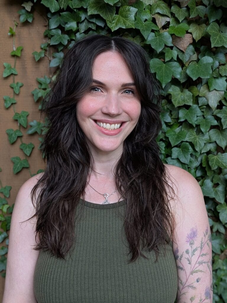 Dark brown layered wavy hair with soft face-framing pieces.