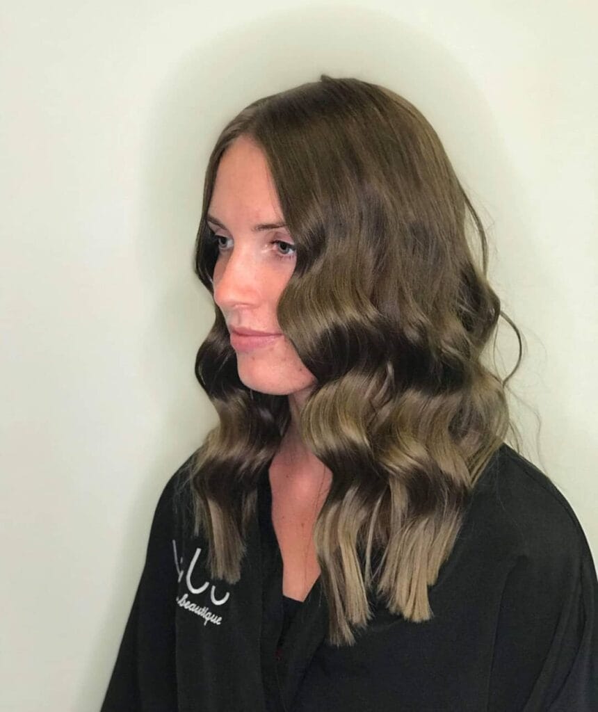 Medium-length brown hair with loose natural waves and a relaxed everyday look.
