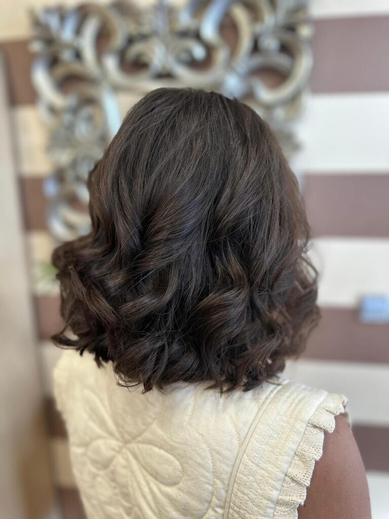 Medium-length dark wavy bob with a rounded shape and soft volume.