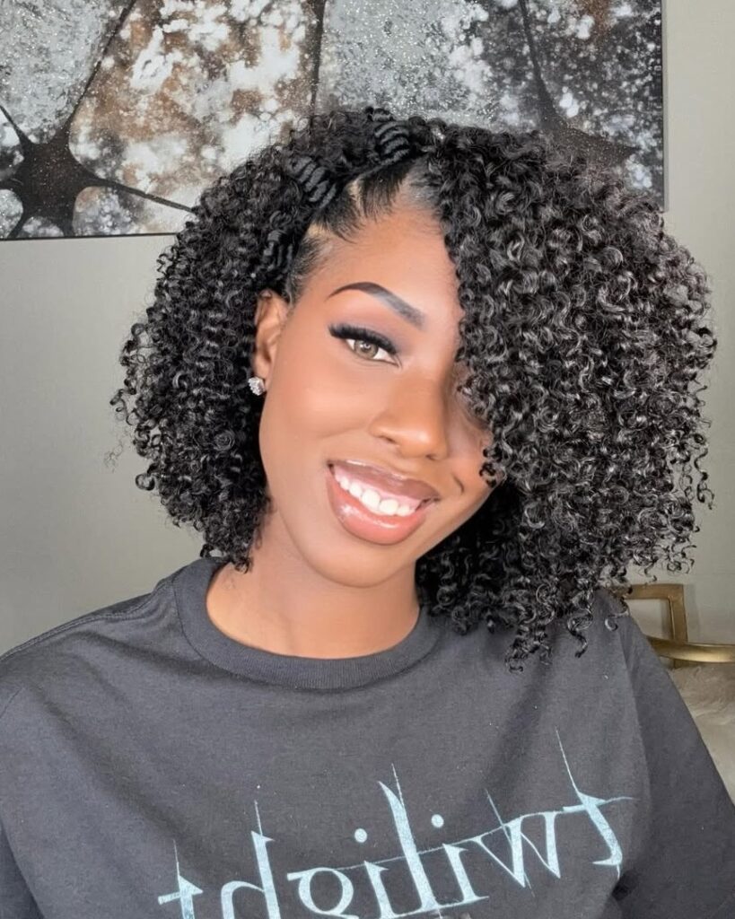 A woman with a defined curly bob styled with side volume and natural texture.