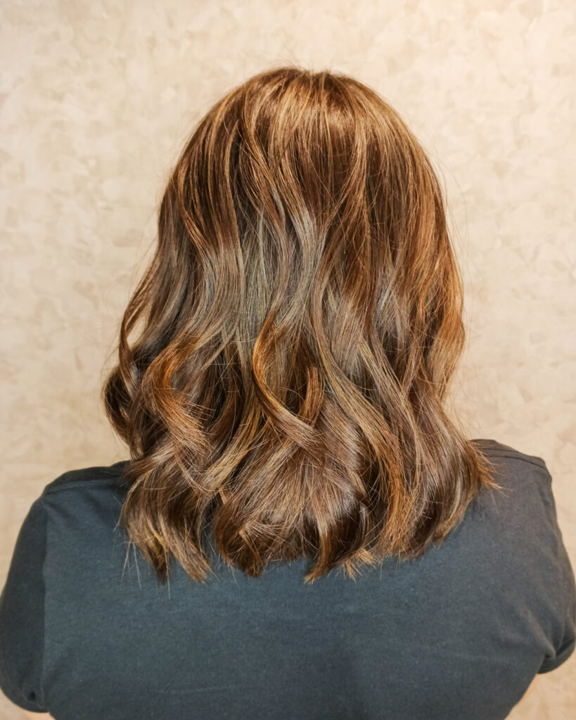 Medium length brown hair with soft textured waves and natural movement.