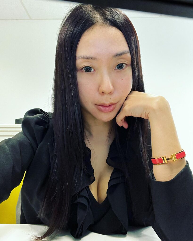 Long straight black hair with a center part and sleek polished finish.