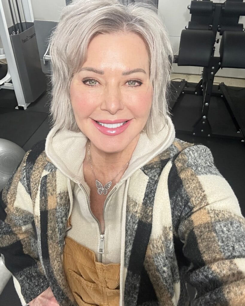 A woman with a neck-length textured silver shag hairstyle featuring choppy layers and wispy bangs.