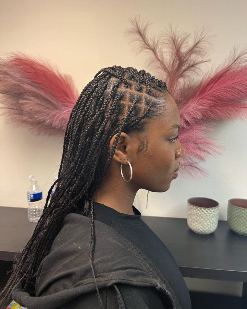 A side profile shows a woman with extra long black knotless braids featuring wavy bohemian tendrils throughout the length.