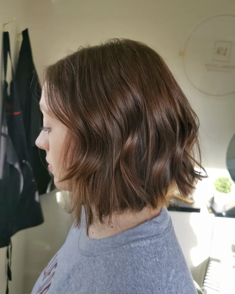 A woman with a classic medium brown wavy long bob with natural movement and soft waves.
