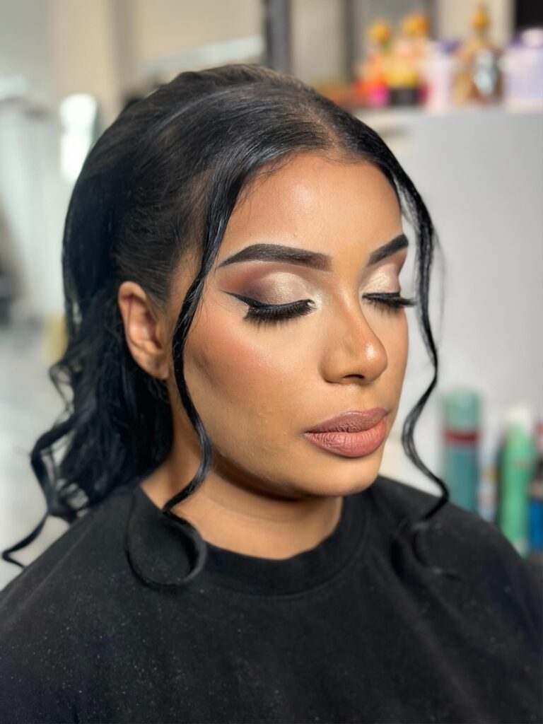 A woman wears a sleek high ponytail with voluminous black curls and two long face-framing strands.