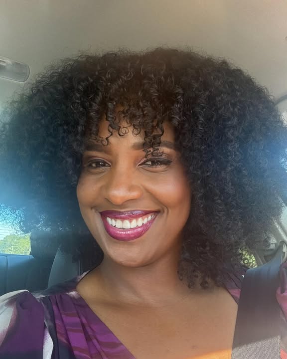Long curly hair with natural volume and curly bangs framing the face.