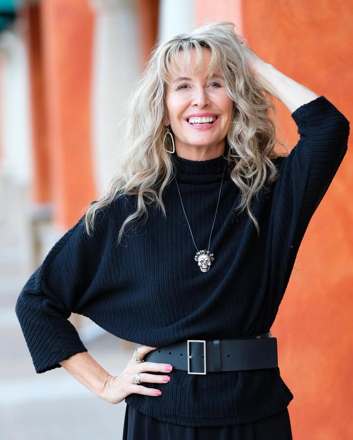 Long curly layered hair with soft bangs and natural volume.