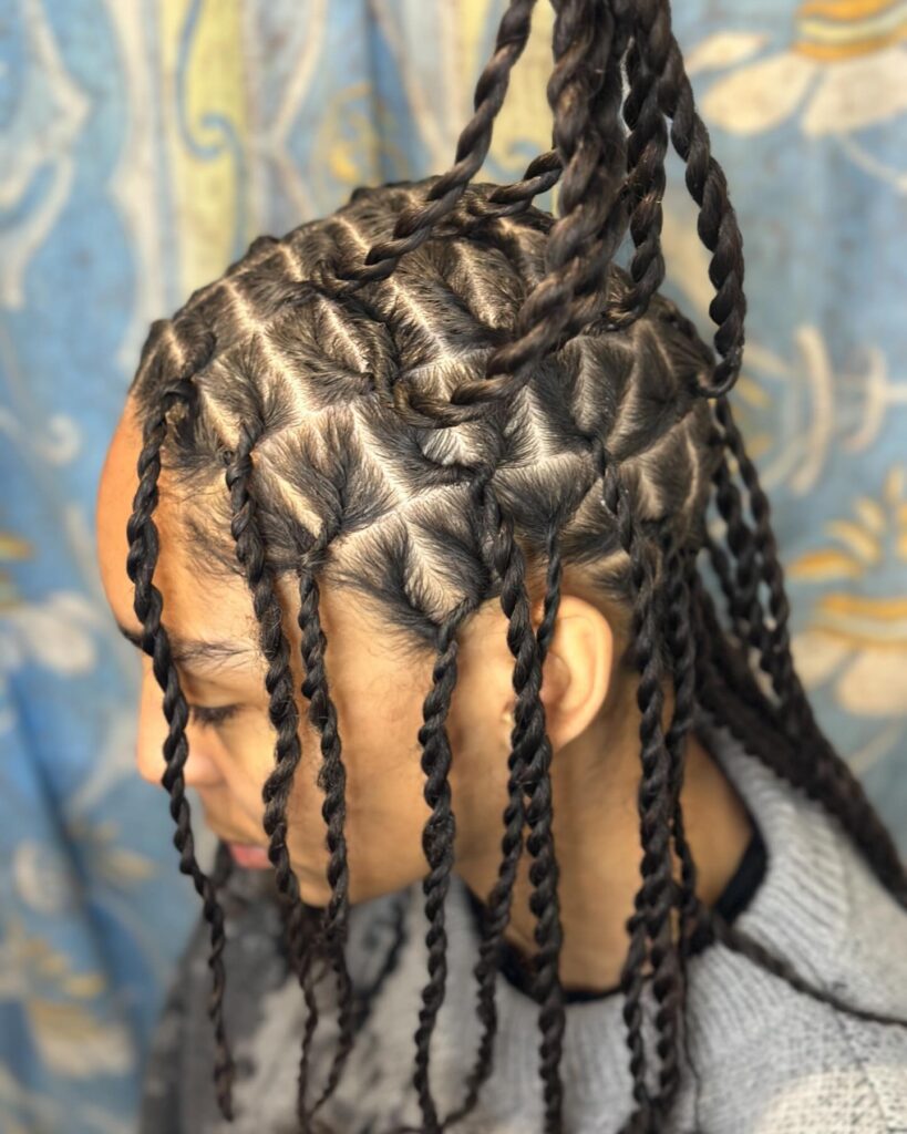 Twisted hairstyle with geometric parting and neatly sectioned scalp design.