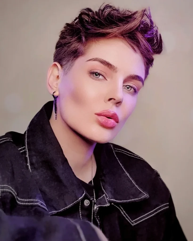 A woman with a short tomboy pixie haircut featuring cropped sides and a lifted textured top.