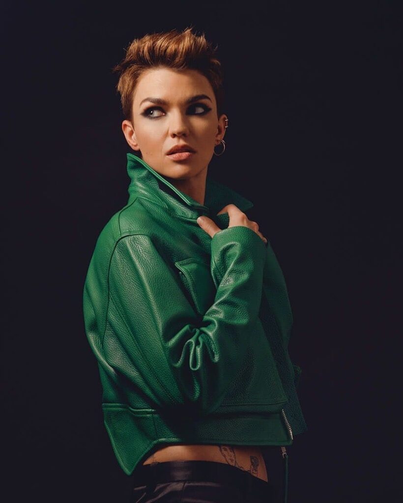 A woman with a short spiky tomboy pixie haircut with cropped sides and a textured auburn top.