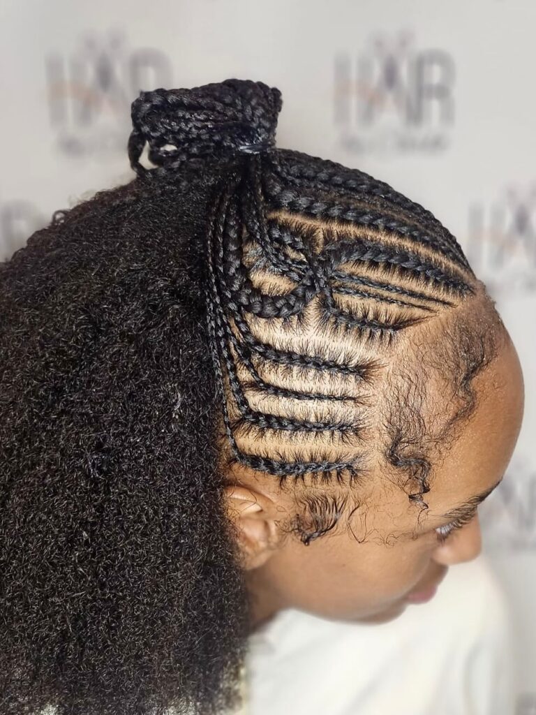 Side cornrows styled into a high afro puff with natural volume.