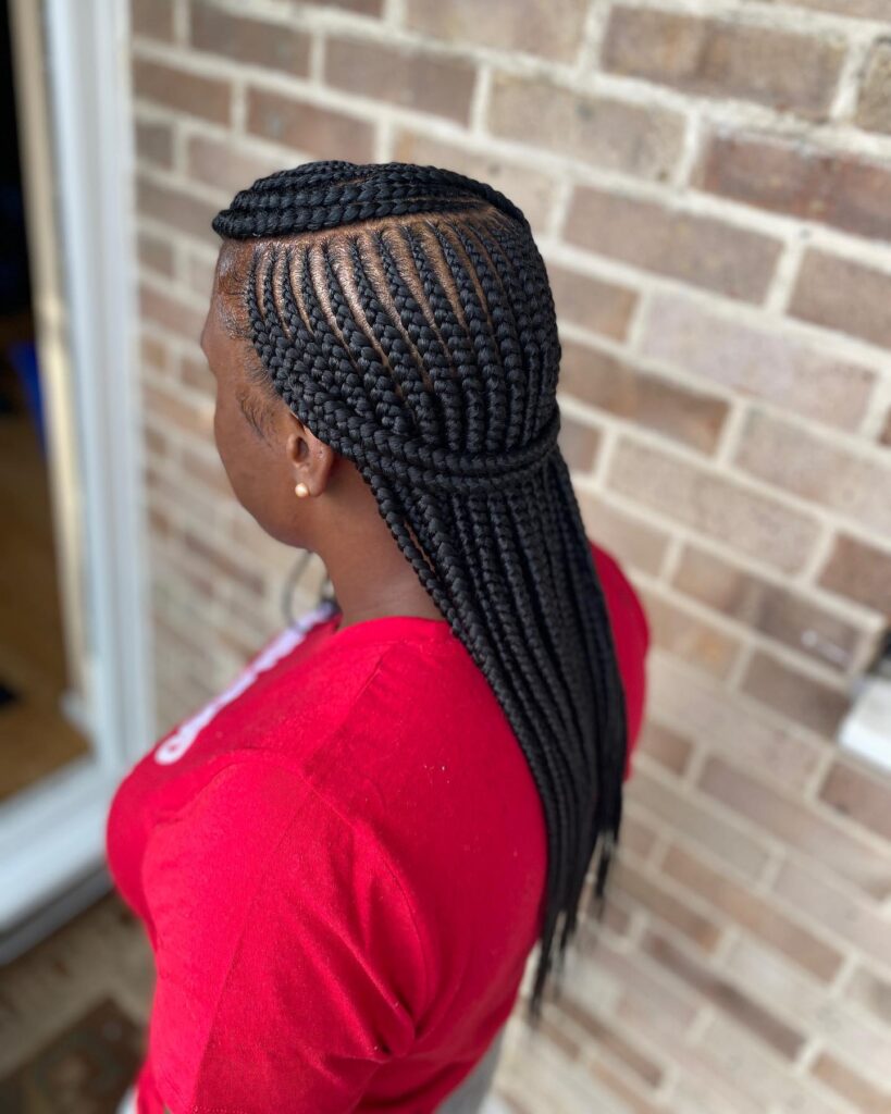 Straight back cornrows styled into long braids with a subtle half up shape.