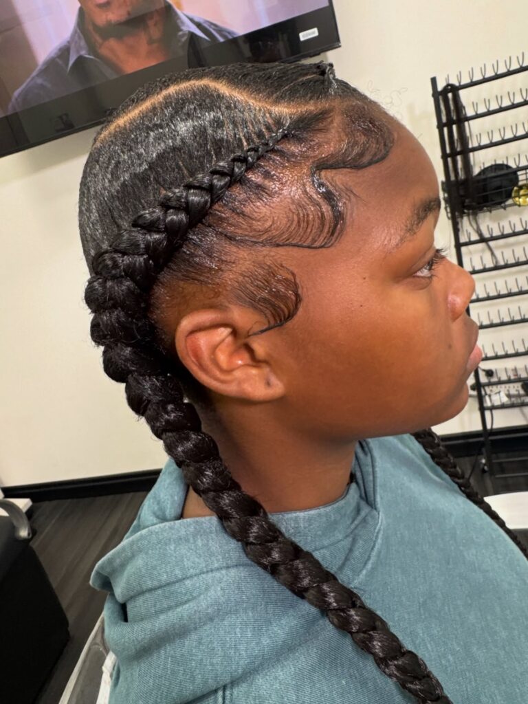 Sleek feed in braids styled into two long thick plaits with laid edges