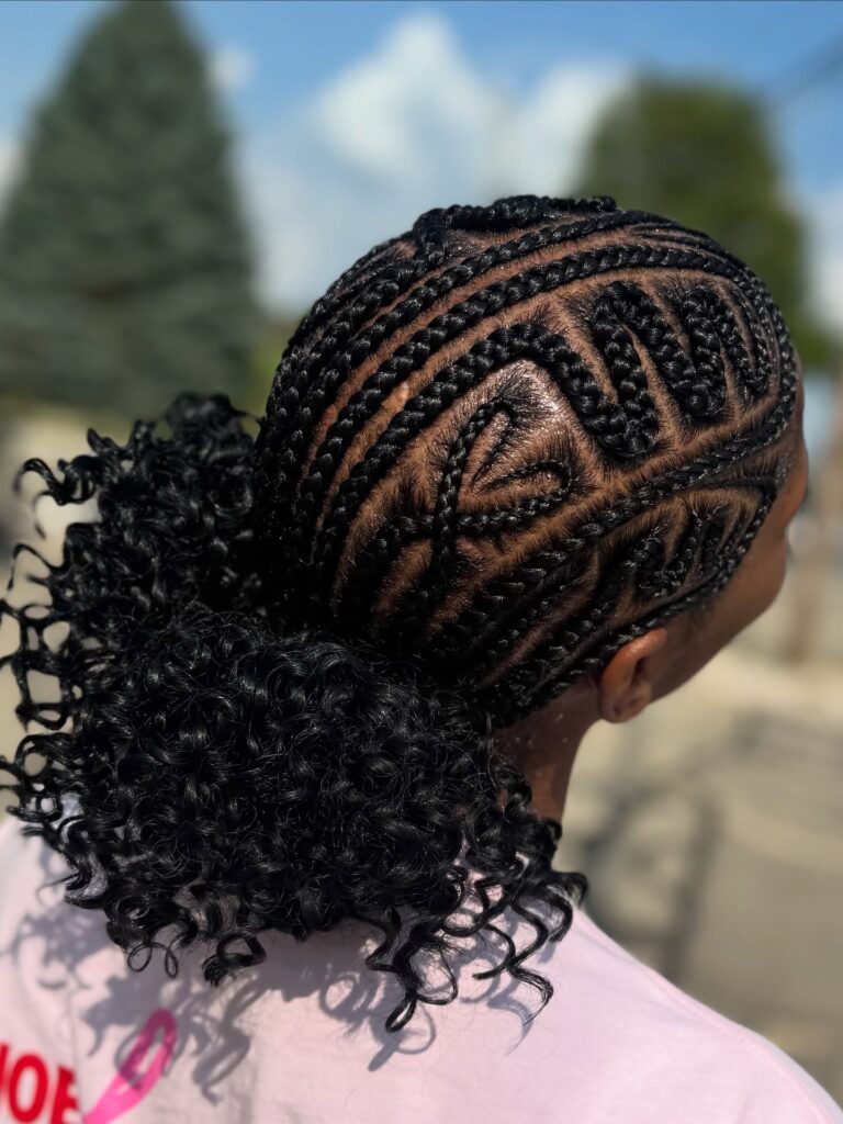 Patterned braided natural hairstyle with a curly ponytail and detailed parting