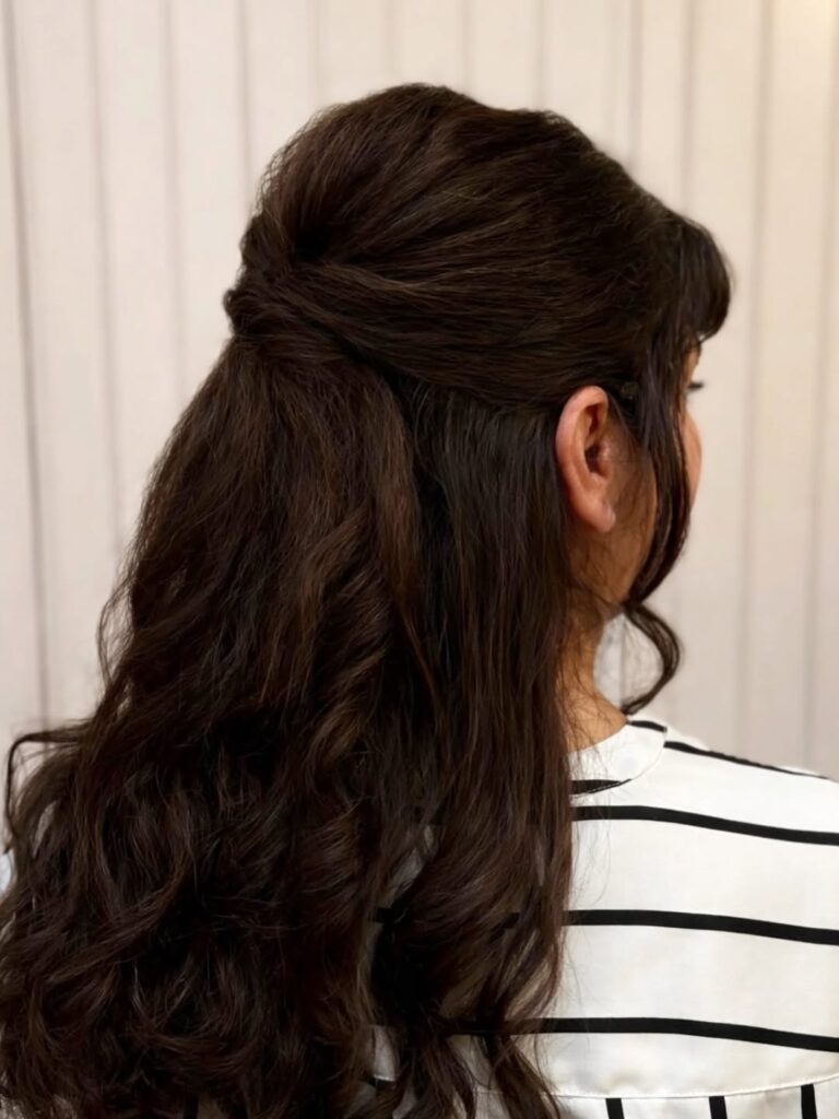 Half up curly hairstyle with soft volume and loose flowing waves.