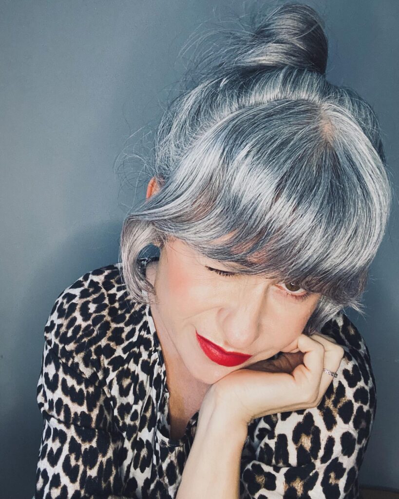 Short silver gray bob with curved side bangs and smooth volume styled neatly around the face.
