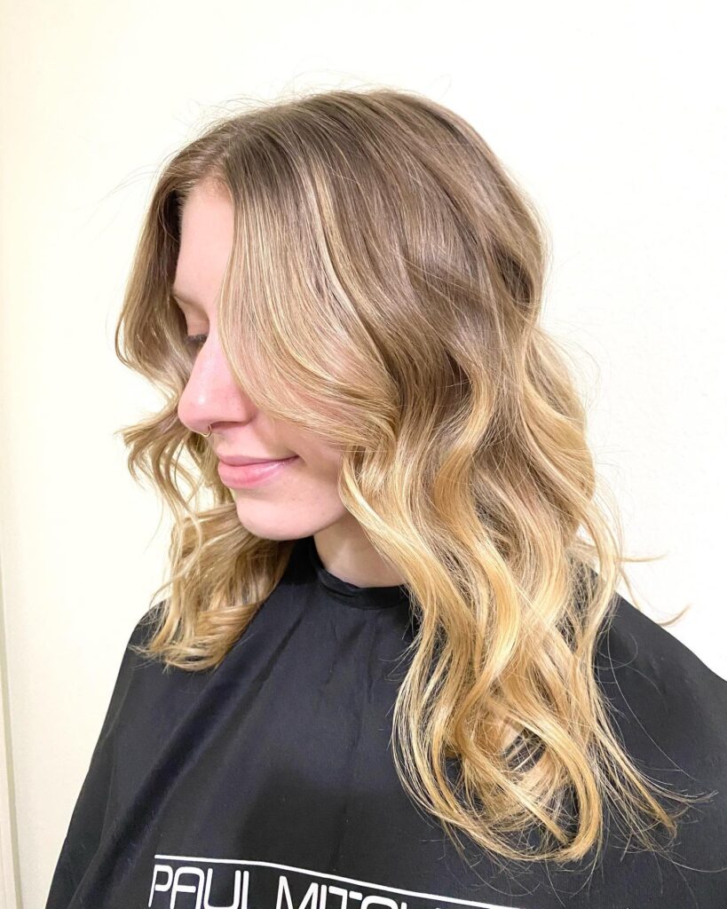 Shoulder length blonde wavy hair with soft face framing layers and natural movement.
