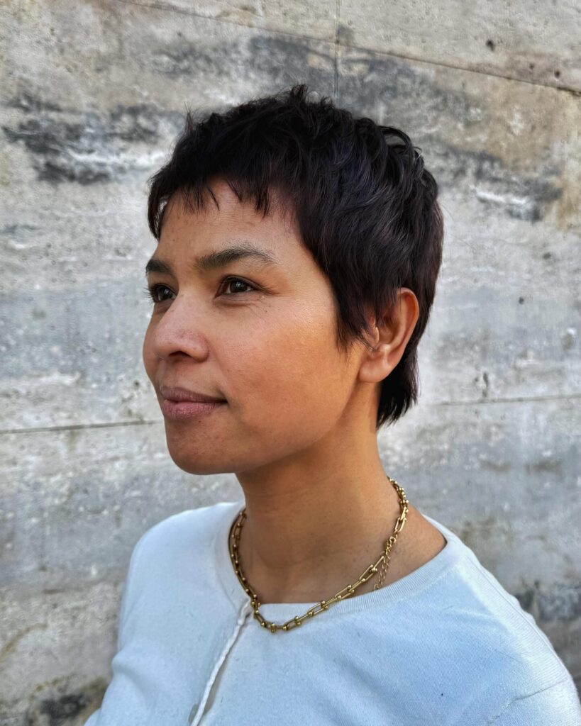 A woman with a short dark tomboy haircut featuring soft layers and natural volume.
