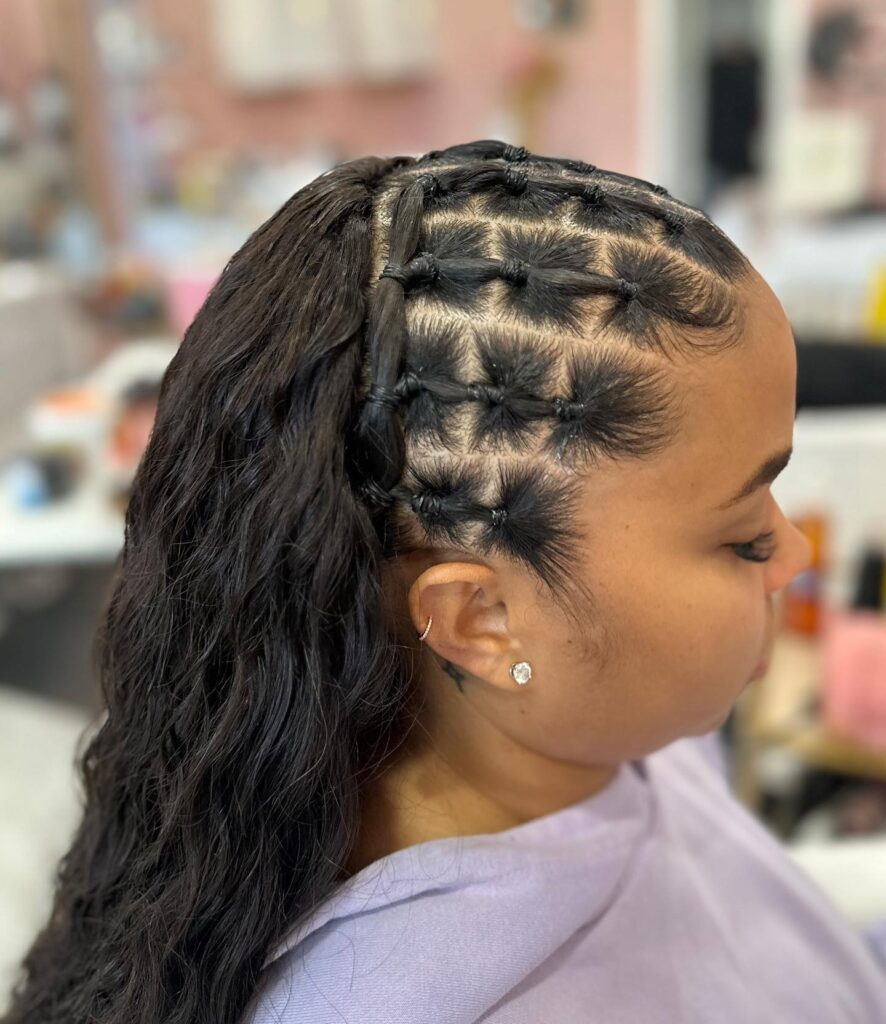 Side rubber band sectioned hairstyle leading into a long wavy ponytail.