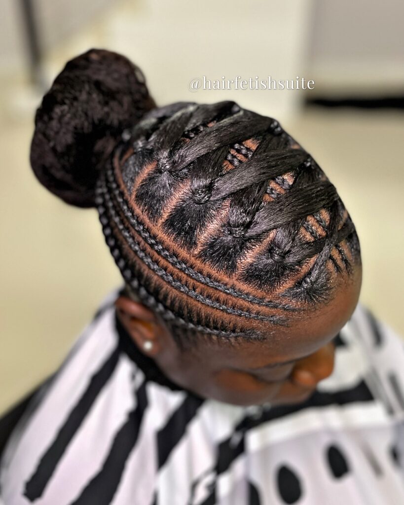 Criss cross rubber band hairstyle with braided sections gathered into a low bun.