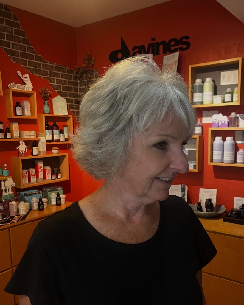 Short voluminous gray bob with soft layered shape and light bangs.