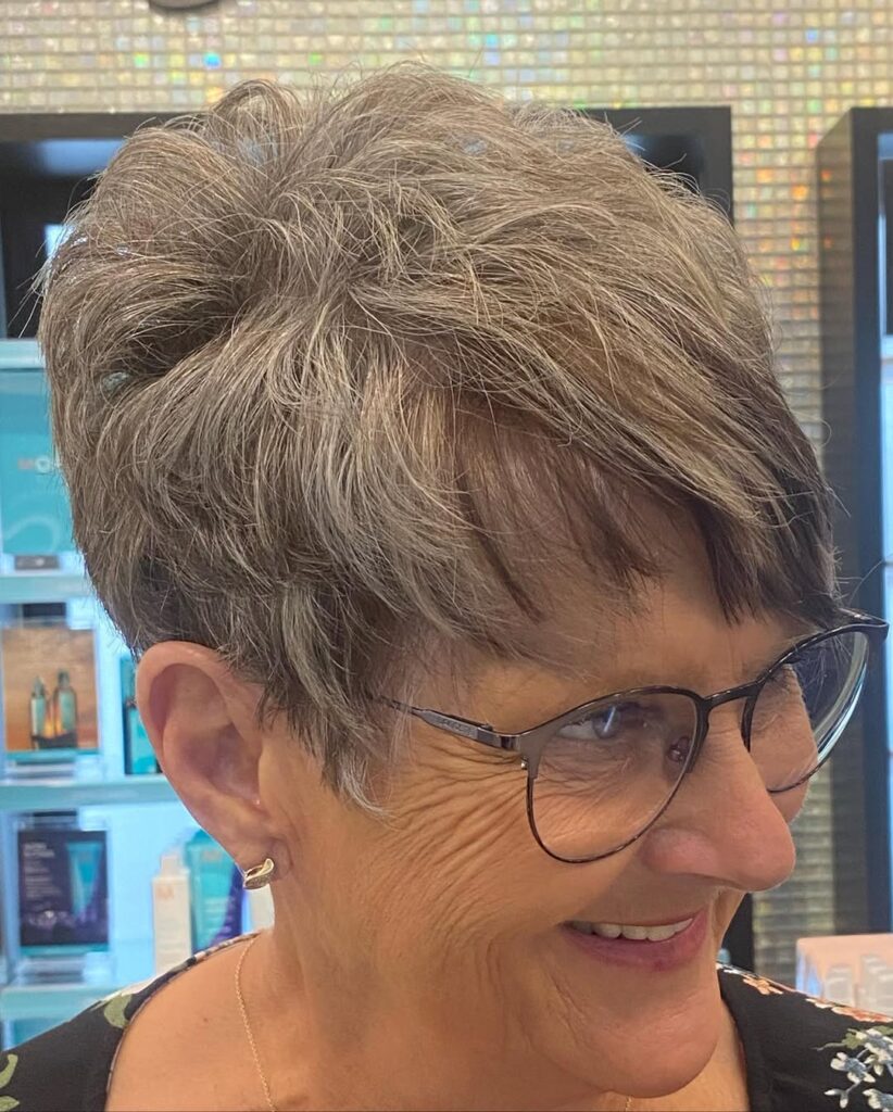 Short textured gray pixie cut with choppy layers and short bangs.