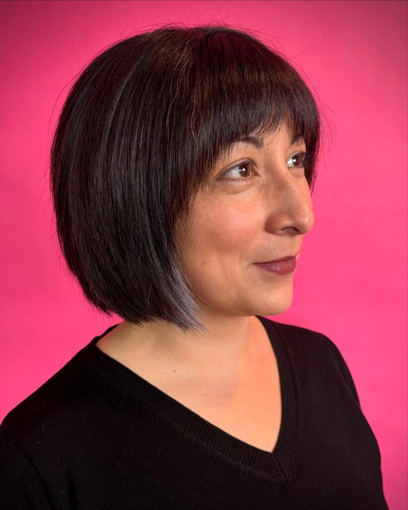A rounded short bob with full bangs and a subtle lighter front section for added contrast