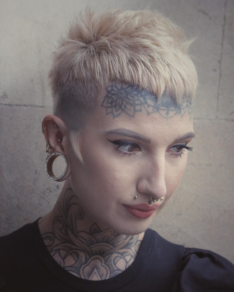 Blonde tomboy pixie with buzzed sides and a blunt short fringe